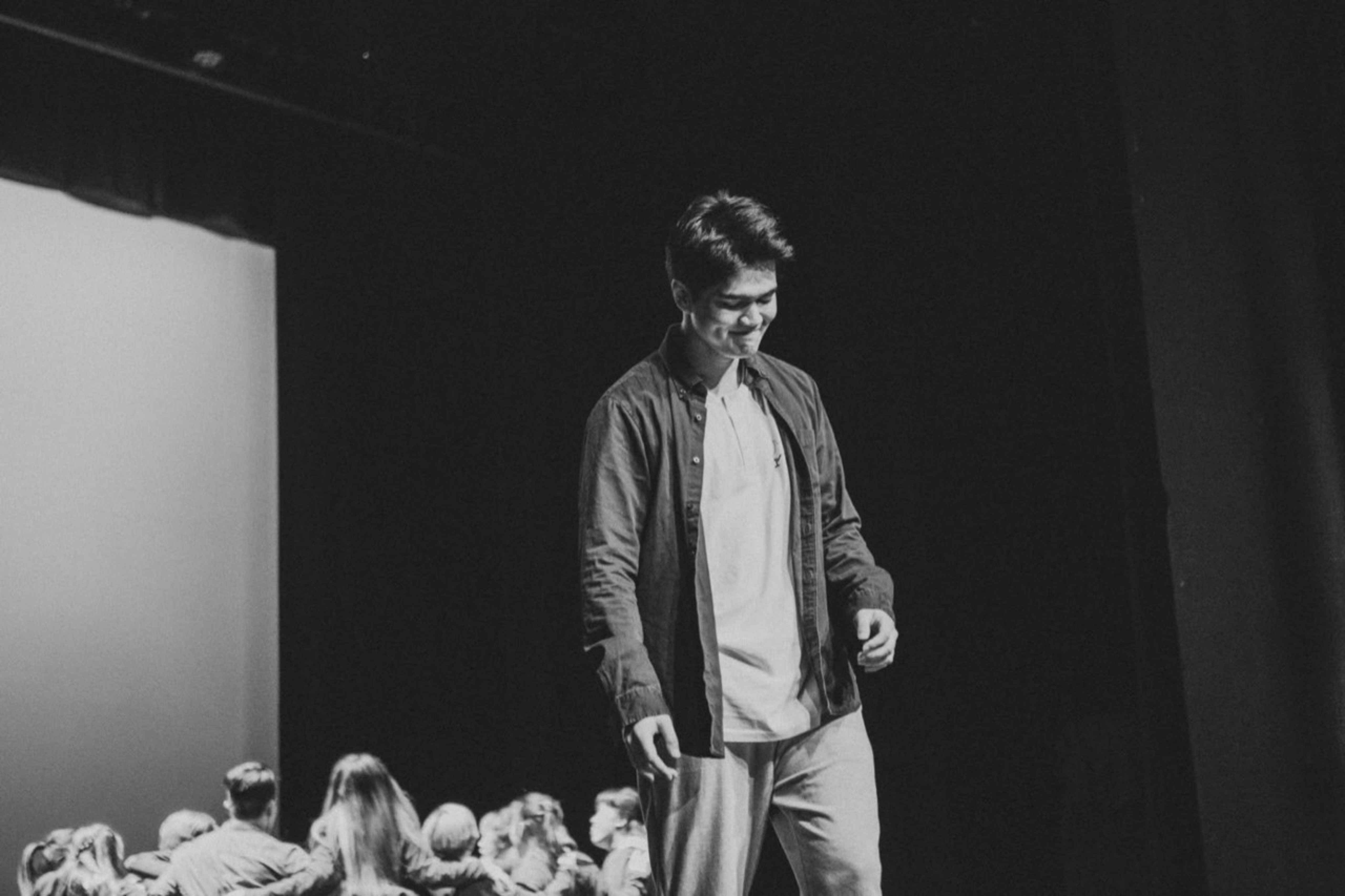 Jericho Mendoza on stage, with an ensemble seated in the foreground